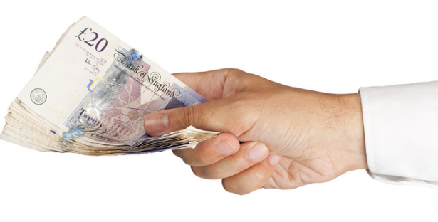An image showing someone handing over british pounds, to represent revenue from their holiday let