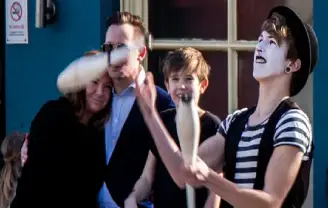 A street performer entertains a family on holidays in the Brighton Lanes.