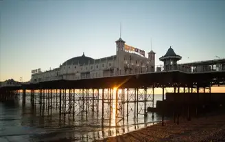 A photo of the sun setting over a holiday on Brighton beach and pier.
