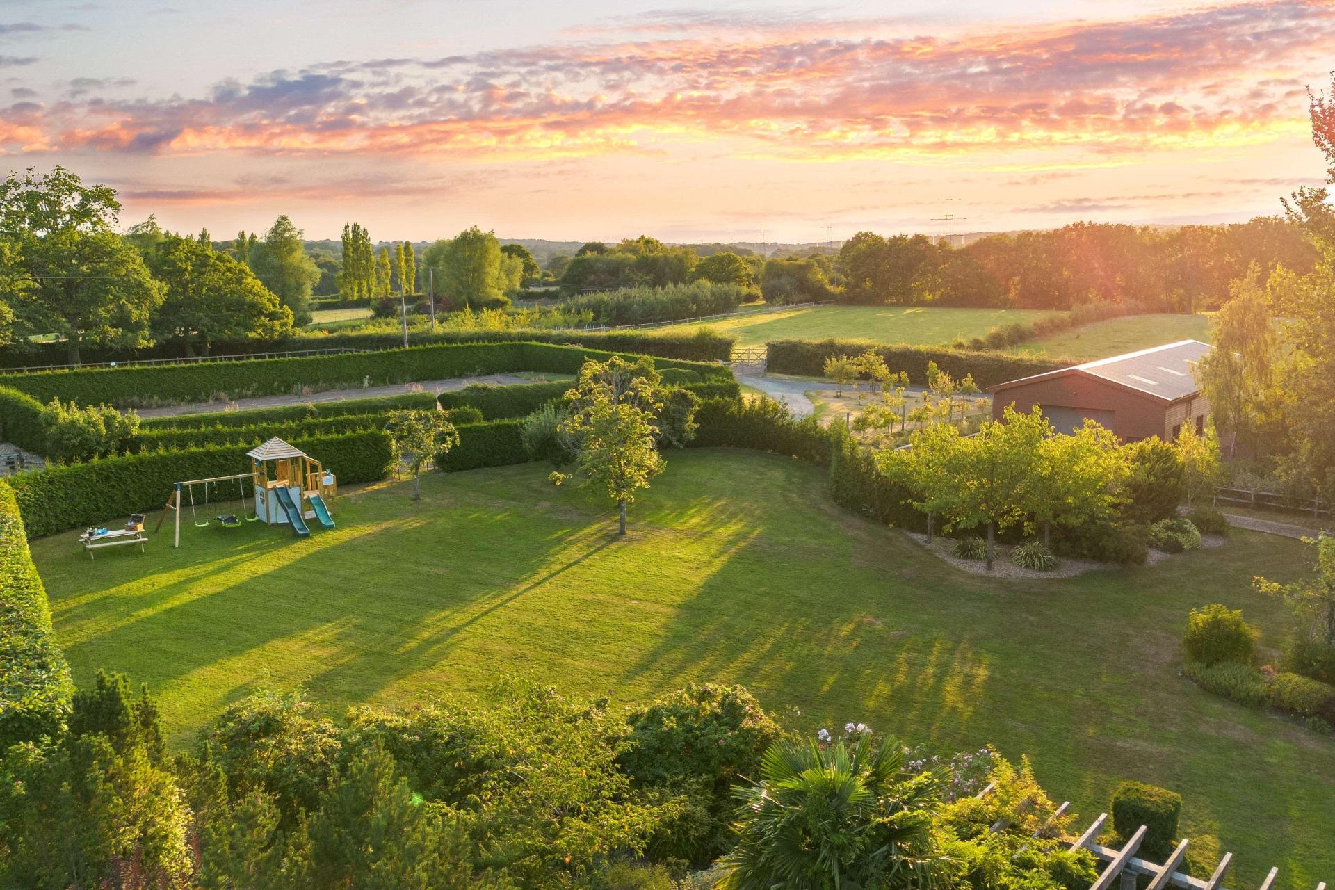 Sunset over the gardens and Sussex Weald countryside at Churchill Country Retreat
